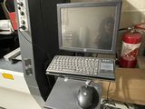 a laptop computer sitting on top of a desk next to a fire extinguisor
