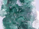 some green crystals are sitting on top of a white surface
