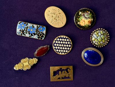 many different types of brooches and brooches on a purple surface