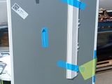 un réfrigérateur posé sur une palette dans le parking