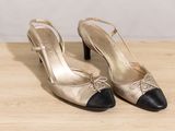 a close up of a pair of black and gold shoes on a table
