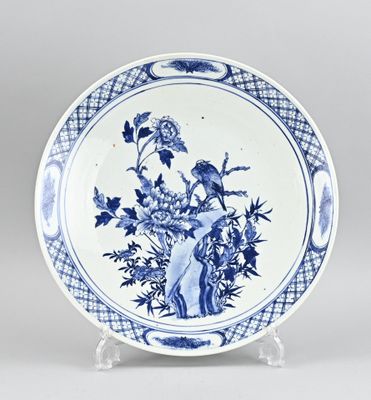 assiette bleue et blanche ornée d'un oiseau et de fleurs