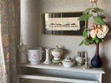 une photo d'une étagère sur laquelle sont posés des vases et d'autres objets