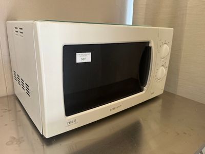 un micro-ondes blanc posé sur un plan de travail dans une cuisine