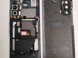 the back of a cell phone with a broken battery and a broken battery cover