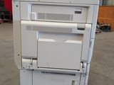 a white printer sitting on top of a cart in a warehouse
