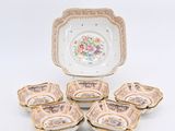 Plusieurs pièces de vaisselle en porcelaine sont posées sur une surface blanche