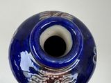 a blue vase with a design on it on a table