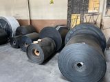 many rolls of black plastic in a warehouse