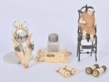a small doll sitting in a chair next to other items