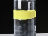 a glass bottle with a yellow tape on it