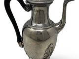 an antique silver teapot with a black handle on a stand