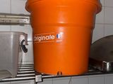 un seau orange posé sur une étagère dans une cuisine