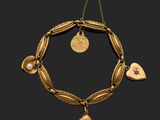 un bracelet en or orné d'un pendentif en forme de cœur et de coquillage