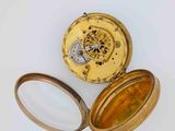 a close up of a gold pocket watch with a magnifying glass
