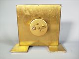 gold plated clock with a flower on the face