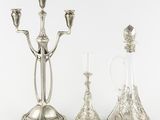 three silver plated candlesticks and a decanter on a white background
