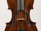 a close up of a violin on a stand on a white surface