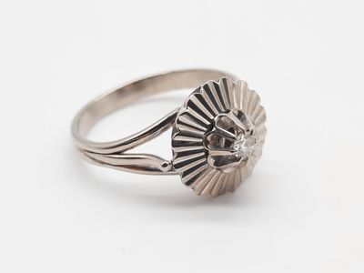 Gros plan sur une bague en argent ornée d'une fleur