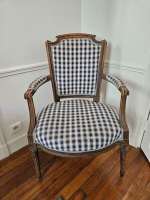 un fauteuil rembourré à carreaux bleus et blancs, placé dans un coin de la pièce