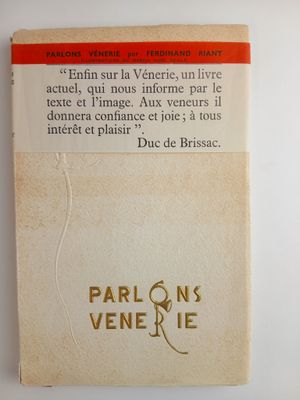 un vieux livre à la couverture rouge et blanche posé sur une surface blanche