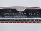 une image montrant un gros plan d'un harmonica dans un étui métallique