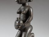 une image d'une statue en bois représentant un homme tenant un bébé