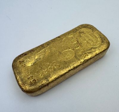 une barre d'or posée sur une surface blanche