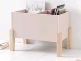 a wooden toy box with books in it on a white floor