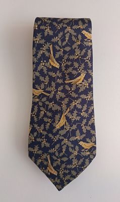 a neck tie with birds on it hanging on a wall