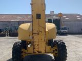 a picture of a yellow tractor parked in front of a building