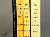 trois livres posés l'un à côté de l'autre sur une table