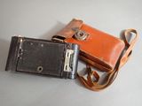 an old camera and an old wallet sitting on a table