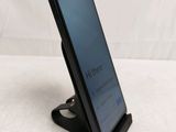 a close up of a cell phone on a stand on a white surface