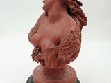 a red busturine of a woman on a black base