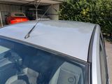 a car parked in front of a garage with a car in the background