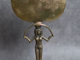une statue en bronze représentant une femme tenant une grande sphère sur la tête