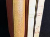 trois livres empilés les uns sur les autres sur une surface noire