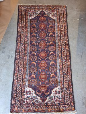 un tapis posé à même le sol, avec un canapé en arrière-plan