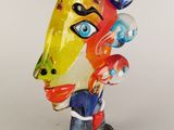 brightly colored glass sculpture of a woman ' s face on a black base