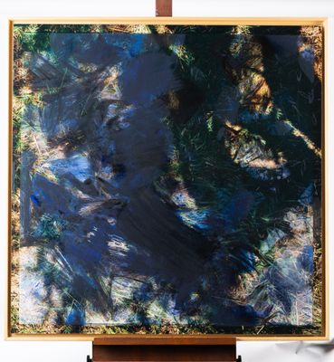 une peinture abstraite représentant un tableau bleu et vert posé sur un chevalet en bois