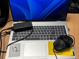 un ordinateur portable posé sur un bureau, avec une souris et un casque