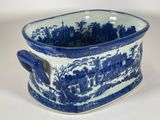 a blue and white cup that has a picture of a town on it