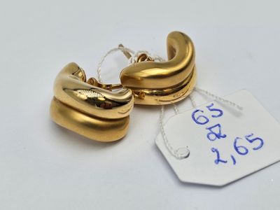 une paire de boucles d'oreilles créoles plaquées or avec une étiquette de prix sur fond blanc