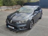 La voiture grise est garée sur le parking à côté du bâtiment.