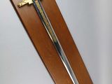 a wooden plaque with a sword hanging on the wall