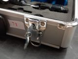 a silver suitcase with a blue handle on a table