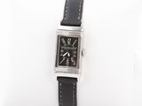 an image of a black and silver watch on a white pillow