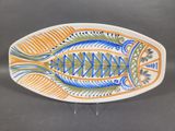 a plate with a fish design on it on a table
