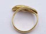 a close up of a gold ring on a white surface